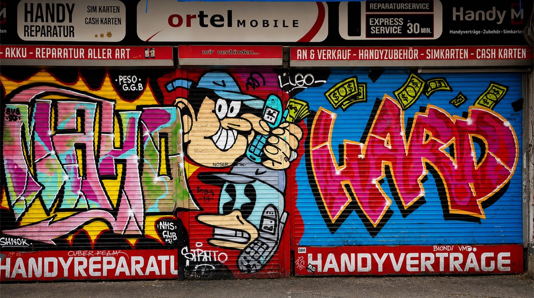 Sprayed shop shutters in Berlin with lettering and a cartoon character