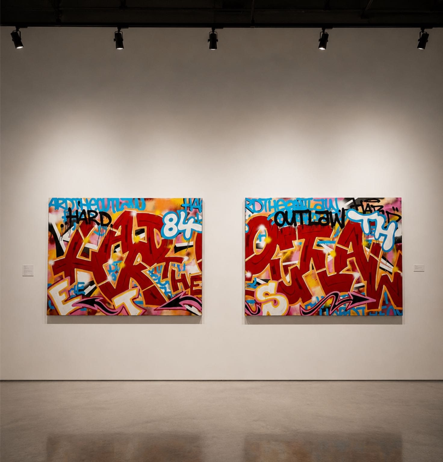 Two large red wildstyle canvases installed side by side in a white gallery