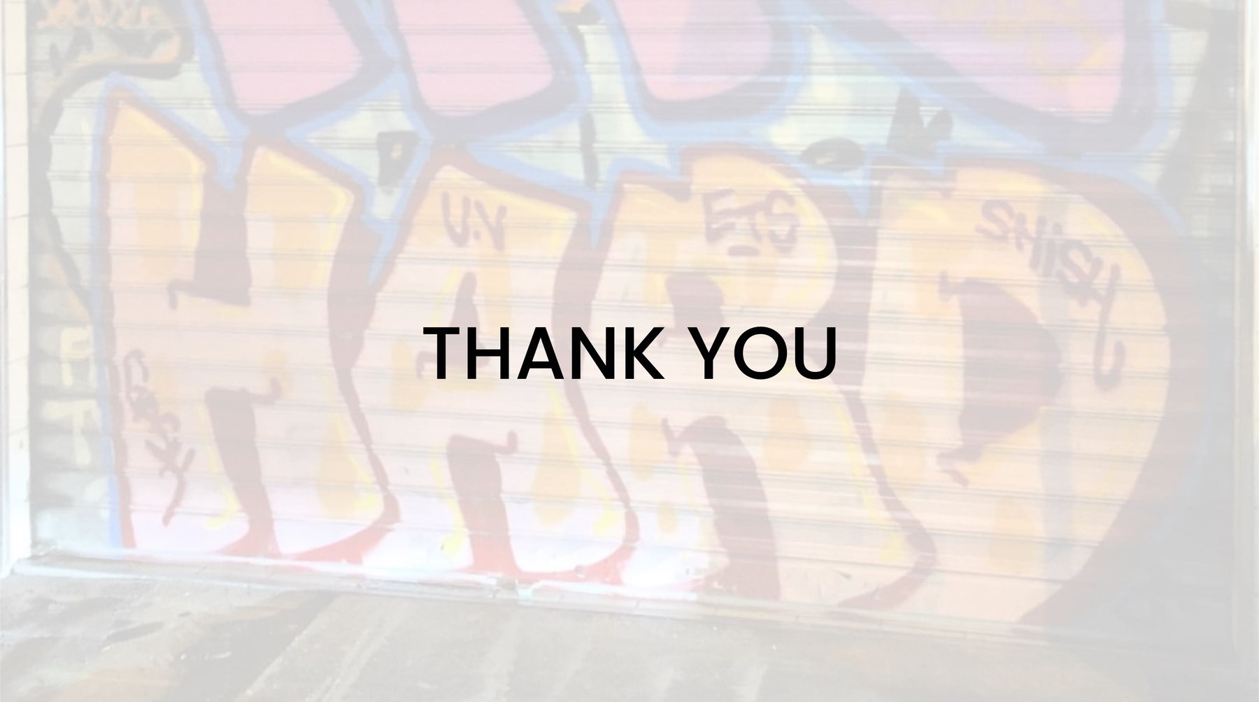 A roller shutter covered in vibrant graffiti lettering, seen from the street